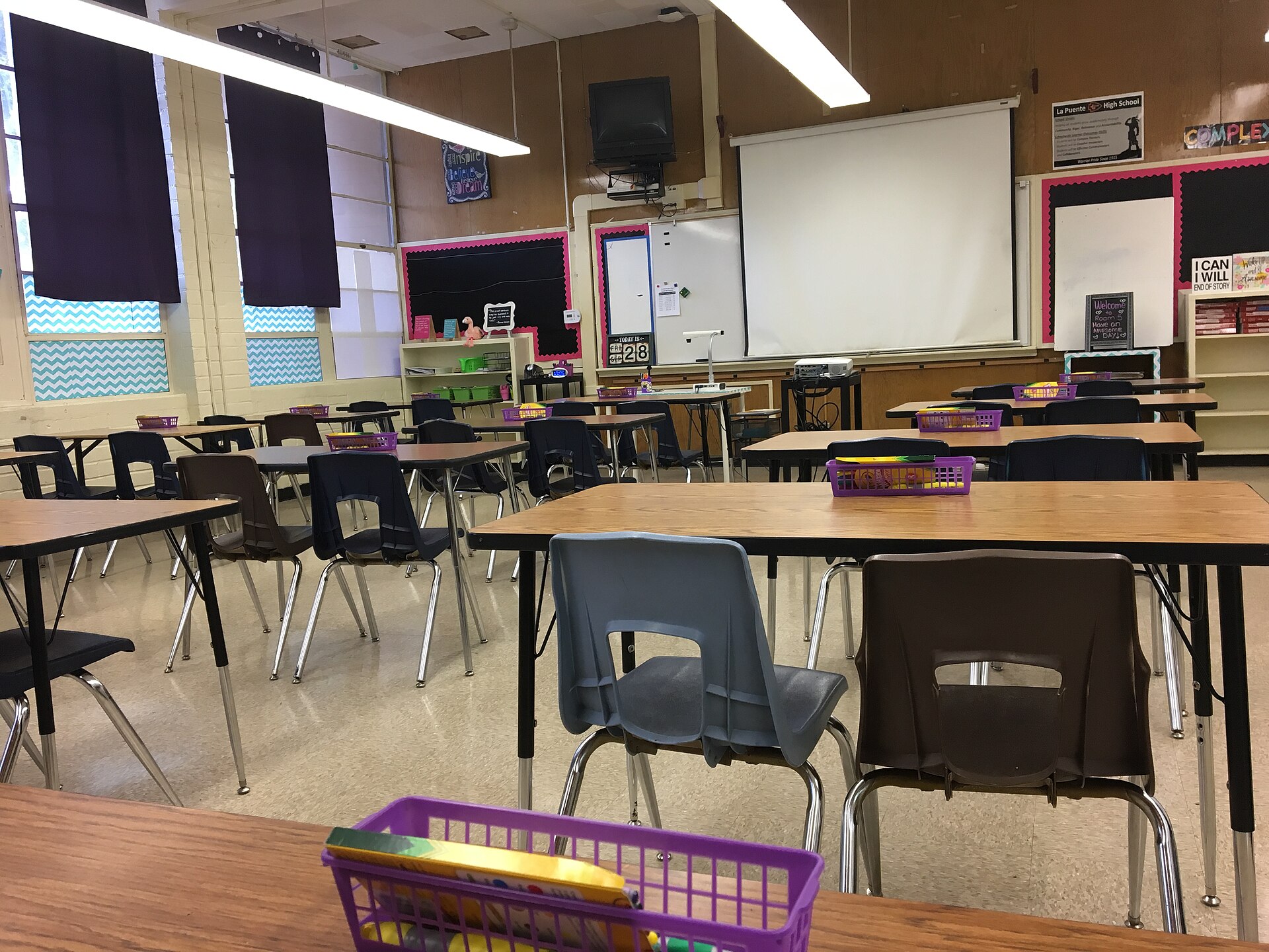 Salle de classe vide avec ses tables, ses chaises et un tableau blanc